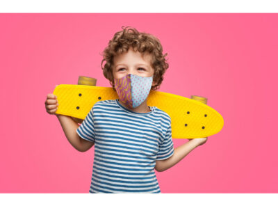 Happy curly boy laughing and holding skateboard